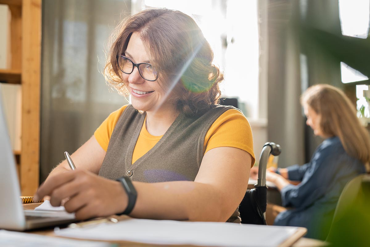 Femme en situation de handicap suivant une formation de comptabilité en ligne.