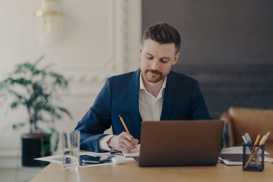 Jeune homme dans son bureau suivant des cours de comptabilité