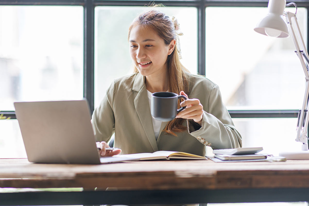 Jeune femme à son bureau en train de suivre une formation de comptabilité à distance.