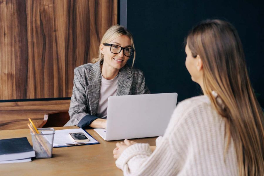 Jeune femme comptable dans son bureau discutant avec une cliente.