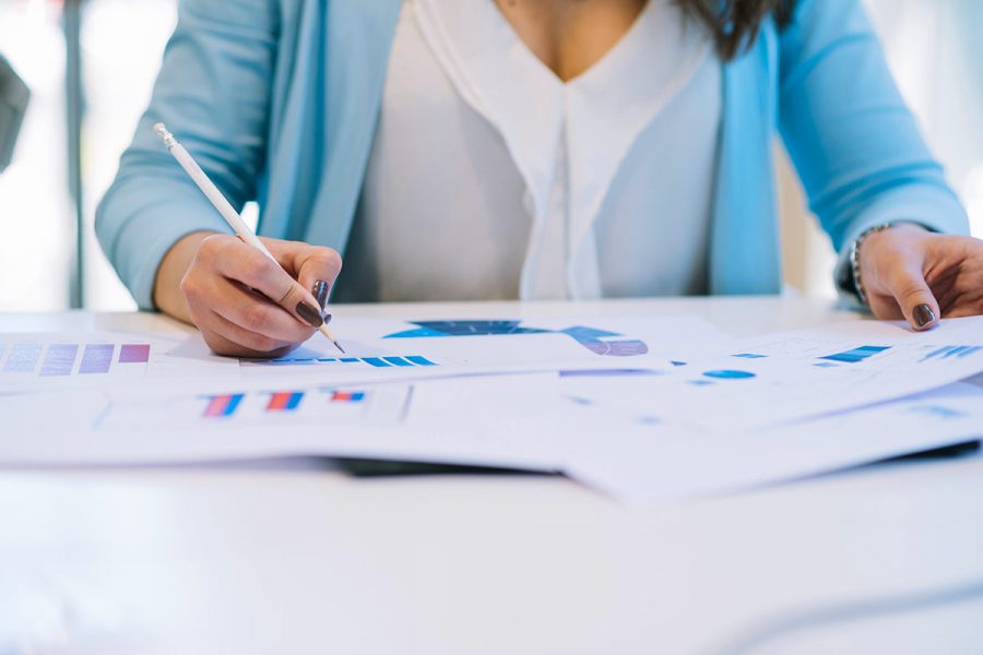 Assistante comptable faisant des calculs et graphiques.