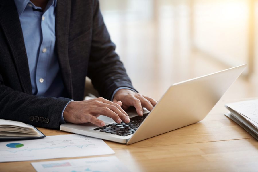 Homme à son bureau en train de taper sur son clavier d'ordinateur