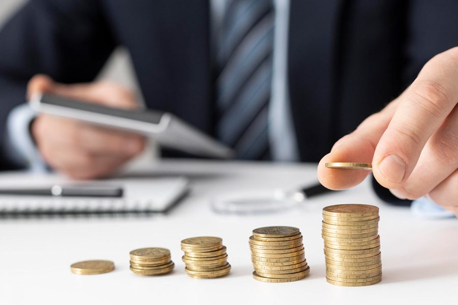 Homme qui aligne des pièces en faisant les comptes