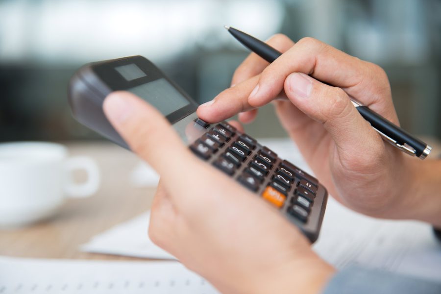 Un candidat à l'examen du dcg en train de calculer sa moyenne générale grâce aux coefficients dcg