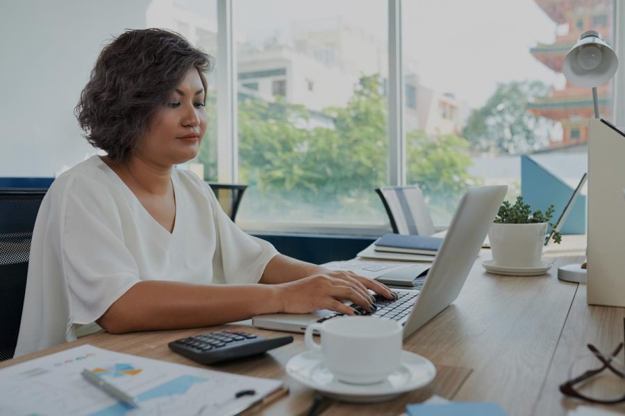 Femme en train de vérifier son salaire d'expert comptable sur son ordinateur