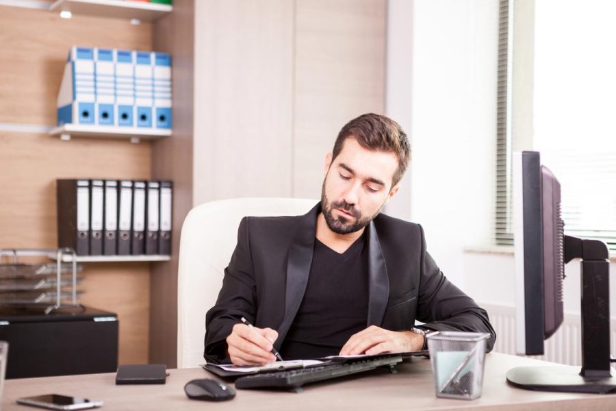 Homme en poste en train de consulter sa fiche de salaire secrétaire comptable