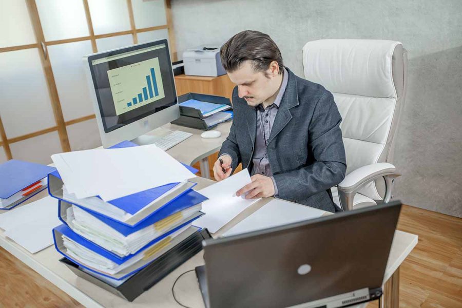 Homme assit à son bureau en tant qu'auditeur junior exploitant ses compétences