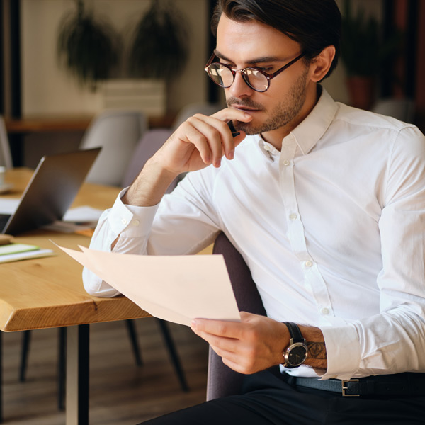 Jeune homme en train de relire sa lettre de motivation avant de postuler à des offres d'alternance en comptabilité avec l'ENCG
