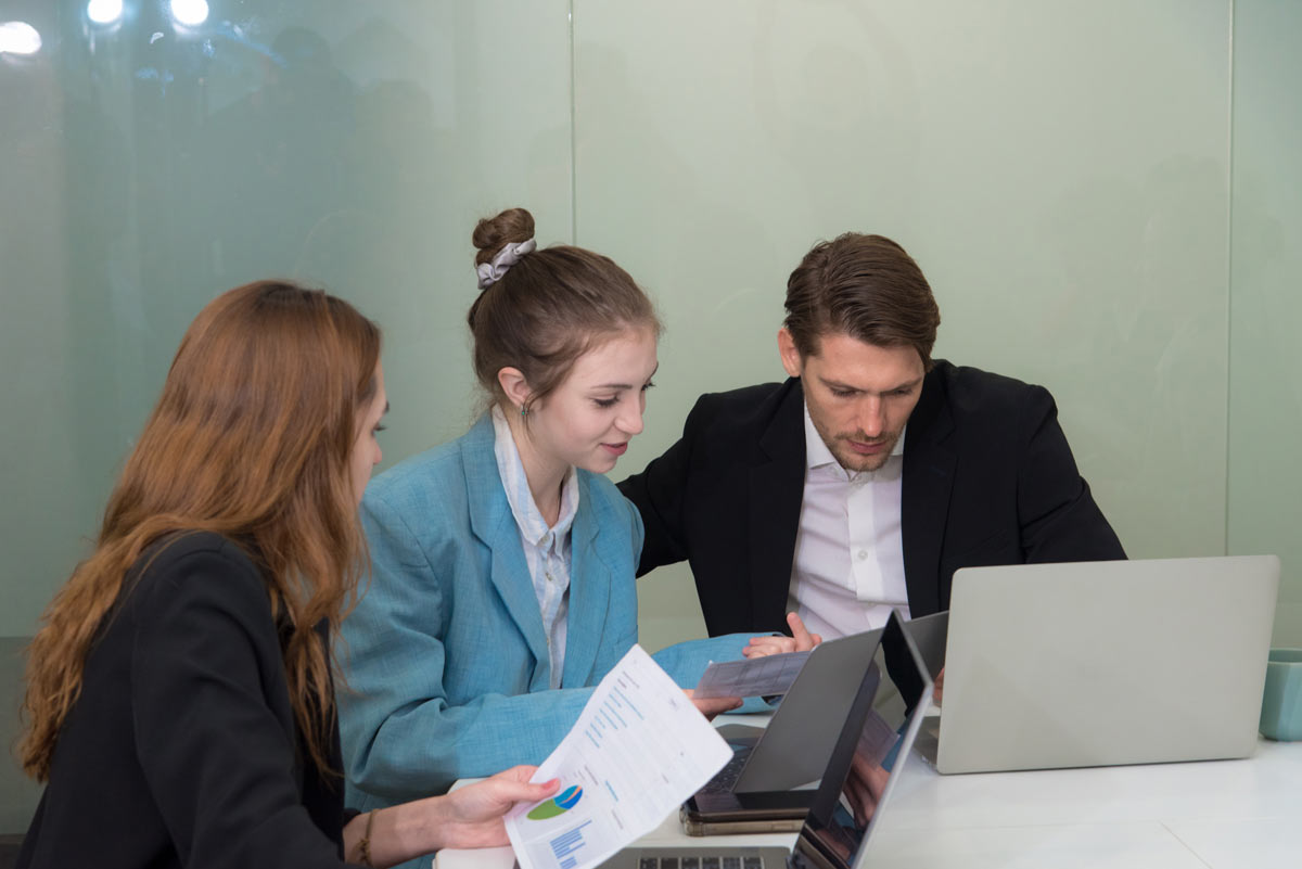 Femme diplômée du DCG avec ses collègues utilisant les UE utiles en entreprise