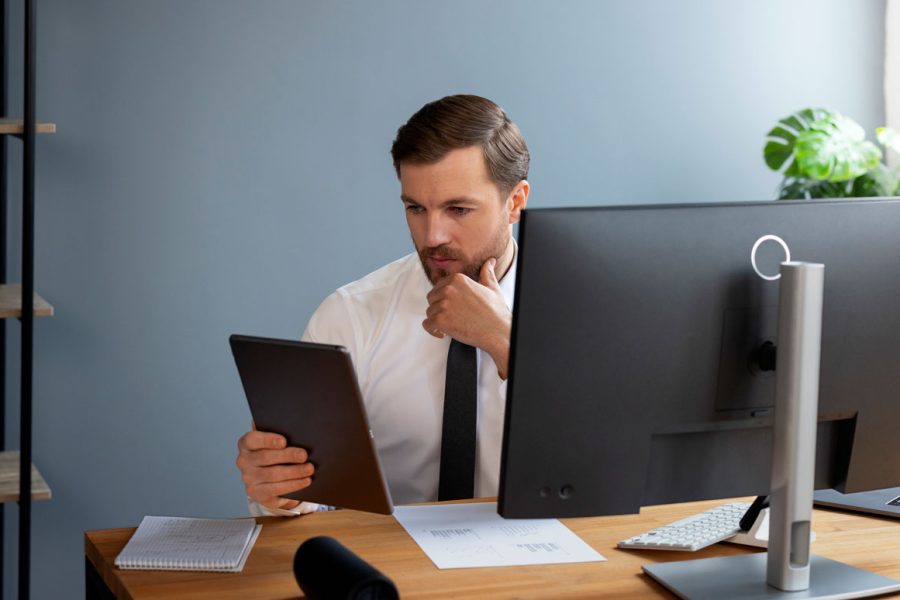 Homme à son bureau en train de se demander s'il peut devenir contrôleur de gestion sans diplôme