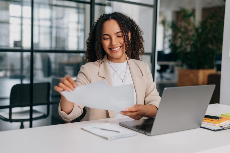 Femme en train de rédiger sa lettre de motivation tp gestionnaire comptable et fiscal pour candidater à la formation