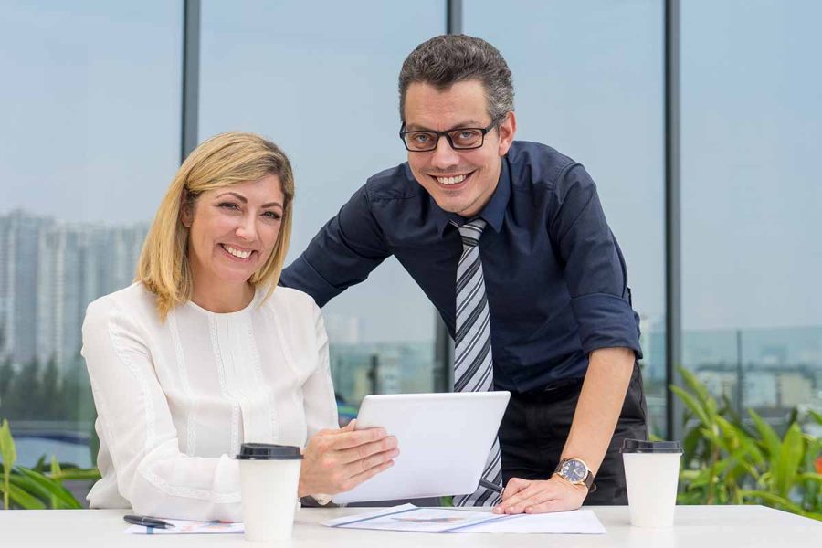 Un homme et une femme travaillent ensemble grâce à l'évolution de la parité hommes/femmes.