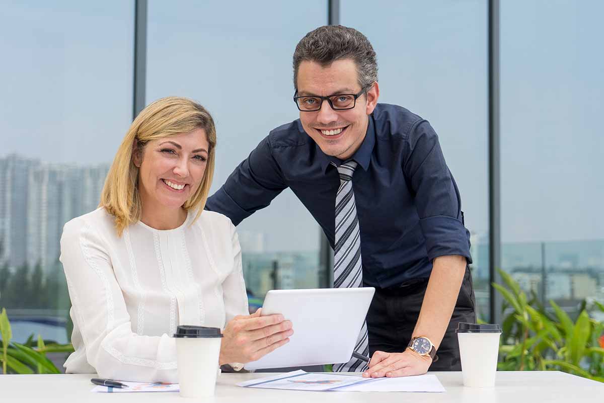 Un homme et une femme travaillent ensemble grâce à l'évolution de la parité hommes/femmes.