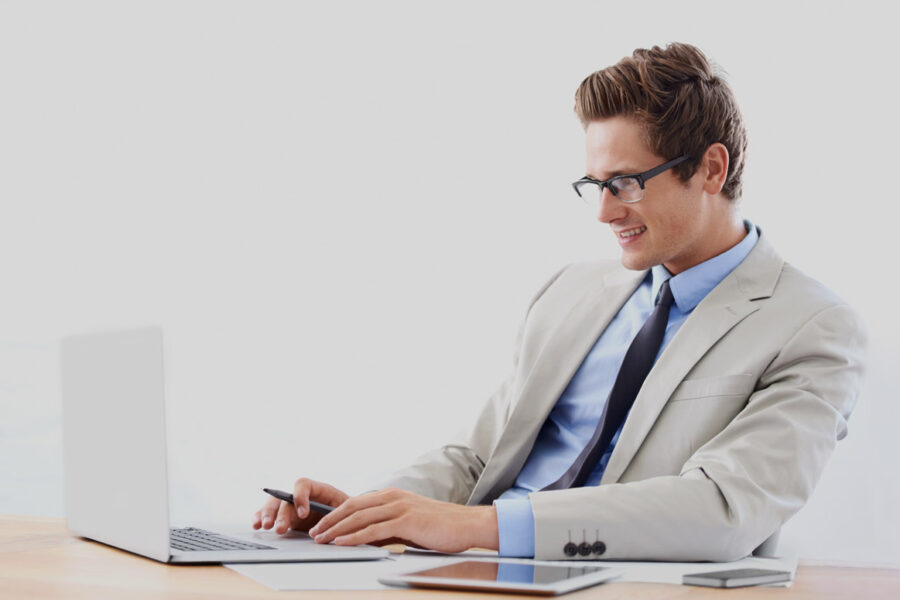 Jeune homme en train de rédiger sa lettre de motivation auditeur interne pour postuler en ligne