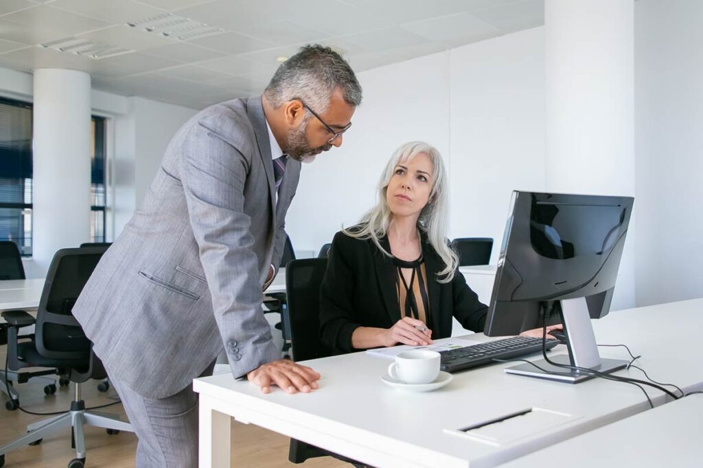 Homme dans sa journée type directeur d'agence bancaire avec une de ses collaboratrices
