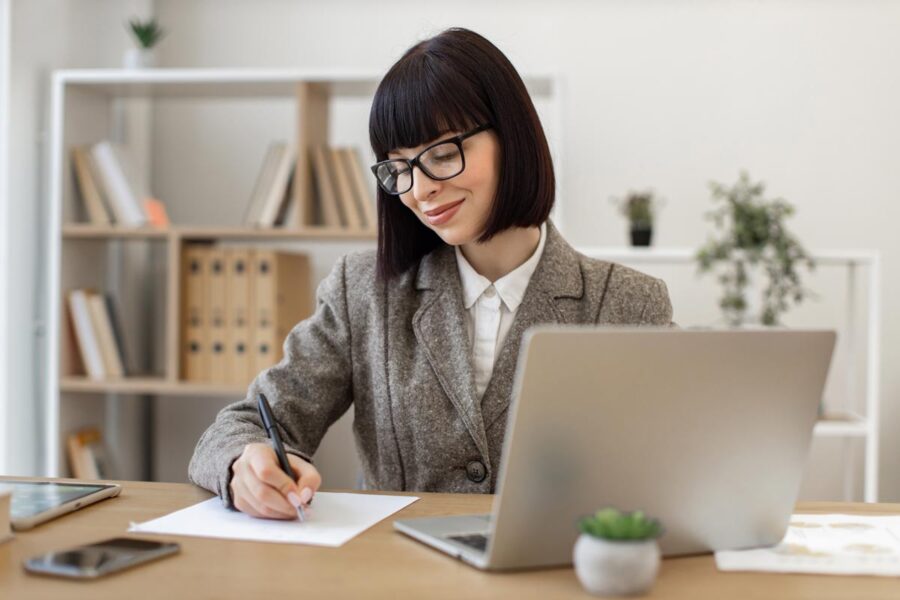Jeune femme travaillant sur la rédaction de sa lettre de motivation comptable.