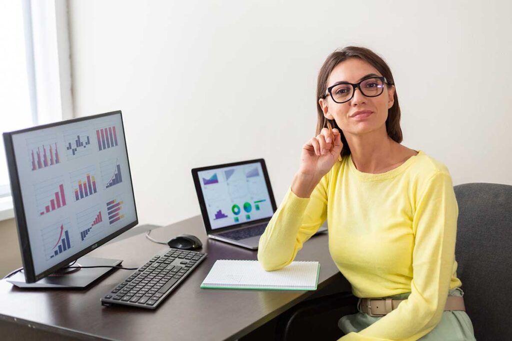 Une femme analyste financière rédige sa lettre de motivation à son bureau.