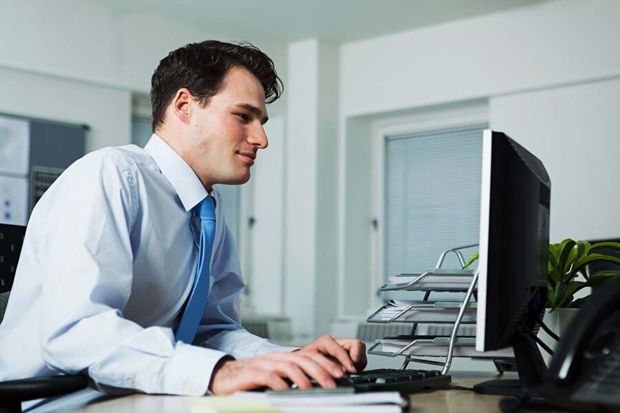 Un homme en études de secrétaire comptable à son bureau.