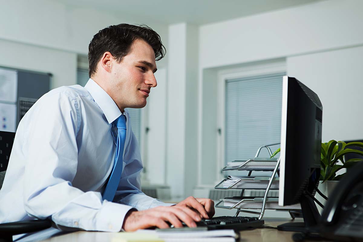 Un homme en études de secrétaire comptable à son bureau.